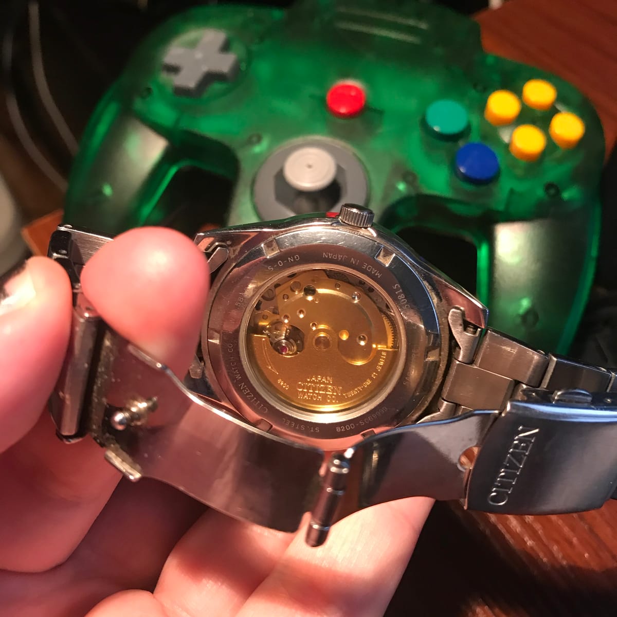 Picture of mechanical watch with Nintendo 64 controller in backgrounde